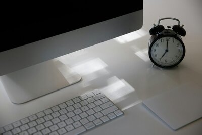 A MacBook with a clock beside it, representing the 'Website in a Day' service for fast web design.