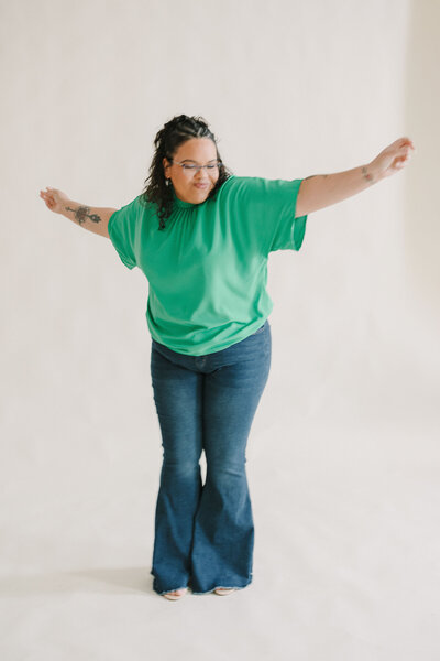 A person in jeans smiling and dancing