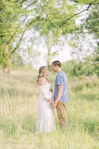 Pregnant mother with husband wearing copper peach dress for maternity photo shoot  Maternity Photographer Louisville KY