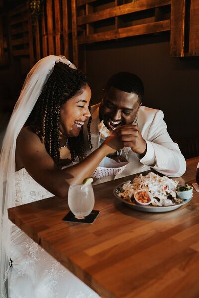 Couple eating sharing nachos captured by Florida elopement photographer Anna Holden Photo
