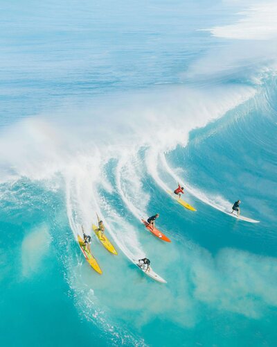 Six surfers catching the same big wave in Hawaii
