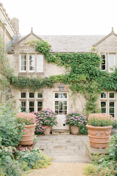 The Lost Orangery Cotswolds wedding venue with an ivy-covered country house facade and terra cotta planters