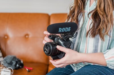 woman putting camera lenses into camera bag