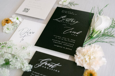 minimal elegant wedding flatlay with invitation suite and all three wedding rings