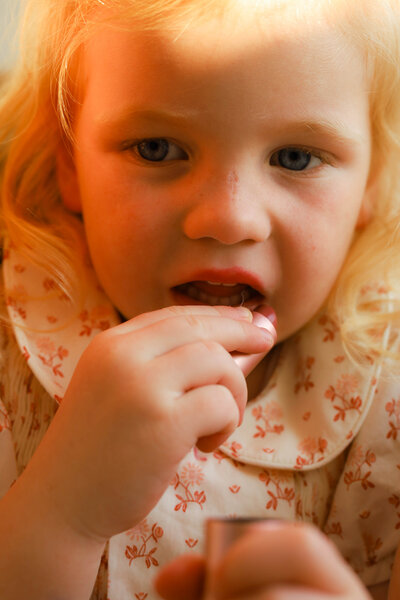 Little girl holds a large beet in the garden, captured in a family session.
