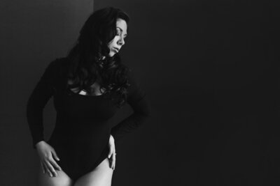 woman wearing a black bodysuit while touching her hips by photographer in Austin Texas
