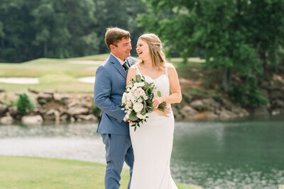 Bride and Groom laughing in front of the Lake at Lake Lanier Islands