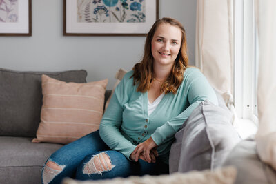Emily sitting on couch, smiling
