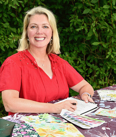 Photo of Ellen Morse with sketchbook and color swatches, design materials