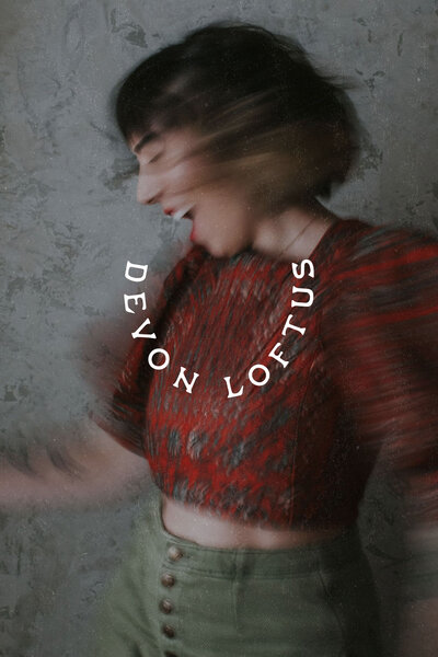 Creative blurred portrait of Devon Loftus with dynamic movement, featuring a minimalist logo design in curved white text.