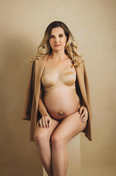 pregnant lady wearing a orange blazer and lingerie for her maternity studio session