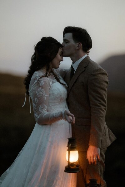 Couple hold each other tight on the banks of a loch within Glencoe, Scotland
