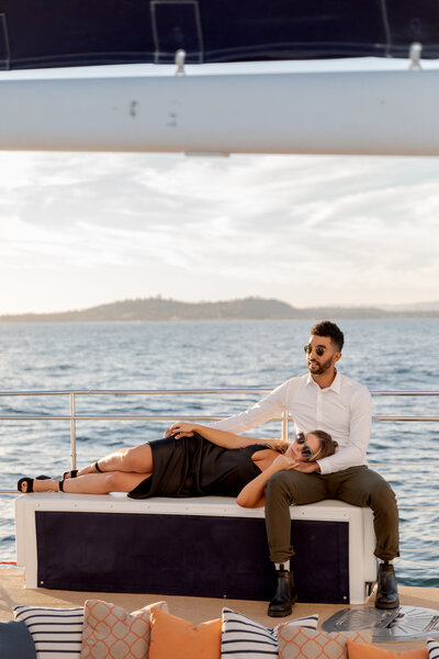 engaged couple relaxing on sailboat for engagement photography