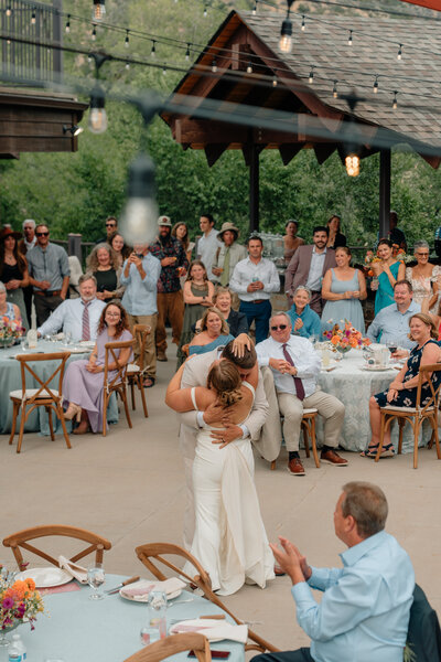 Couple dances and hugs on patio at their summer Glenwood Springs wedding. 