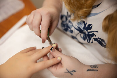 Close-up of a professional pedicure treatment at Intrigue Salon's Body Studio, featuring toenail polish application for a luxury spa experience.