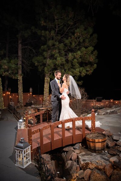 Bride and groom hugging on a bridge at night