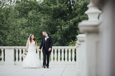 The Palace at Somerset Park | Wedding couple holding hands walking on stone patio | Somerset, New Jersey