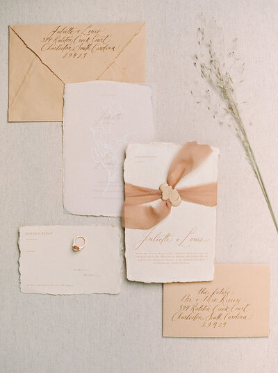 Peach colored wedding invitations with monochromatic calligraphy, silk ribbon belly band and custom wax seal