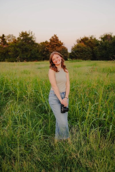 sydney chapman holding camera in field