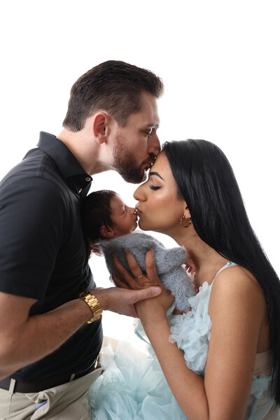 Syracuse photographer, family, mom, baby, dad, gowns, classic, photoshoot, photography, neutral, backdrop, studio, backlit, family of three, kisses