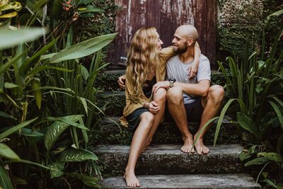 Relationship and intimacy coach with husband sitting on steps surrounded by plants