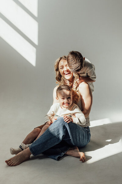 Motherhood session photo in a studio with mom and two young boys