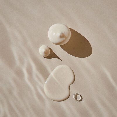 skincare creams on a neutral background with reflected light