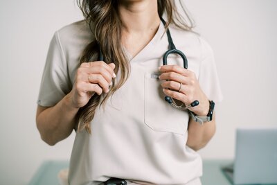Nurse wearing tan scrubs and holding a stethoscope