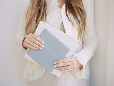 close up of a woman holding wedding albums