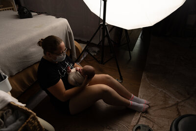 Intimate maternity moment featuring a mother-to-be in a studio setting with soft, ethereal tones, Oswego NY Studio