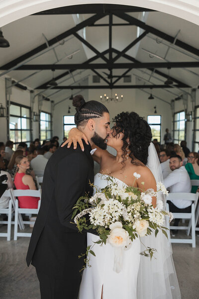 downtown wedding photos with bride and groom. white wedding dress and white flowers and bouquet. groom kissing bride and being romantic for bridal portraits