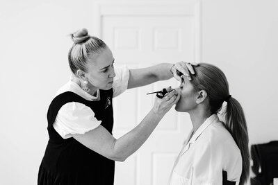 make up artist applying making on beautiful woman for her alyce holzy boudoir session in mackay