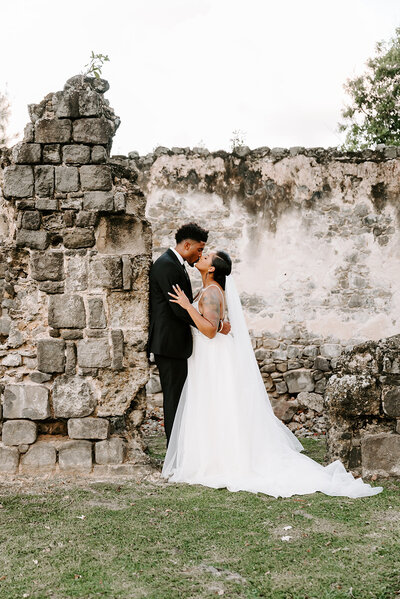 bride and groom kissing at pigeon island in st, lucia