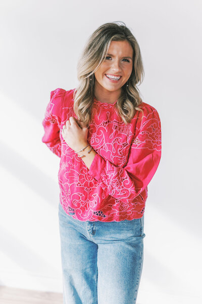 Headshot of Lindsey Kristian in a bright pink top and jeans