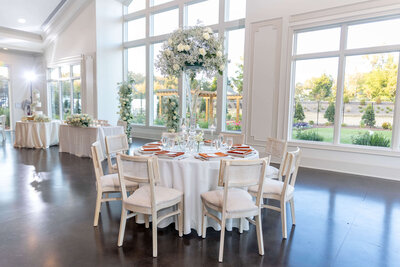 Chic wedding reception setup with white decor and natural lighting at a luxury Raleigh venue.