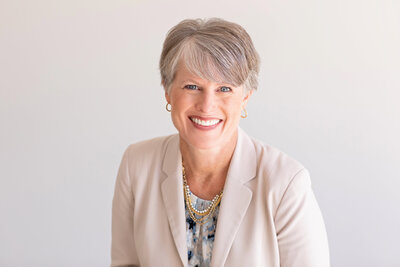 an older woman in a beige blazer for a corporate headshot