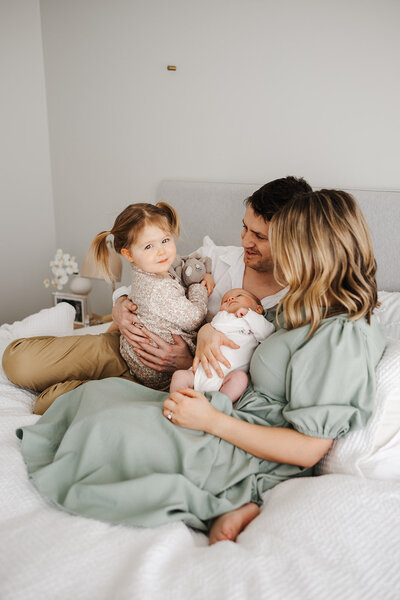 family sitting on bed candidly