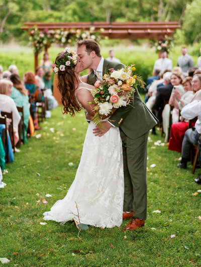 Romantic wedding aisle lined with floral arrangements of white hydrangeas and soft greenery by Leigh Florist