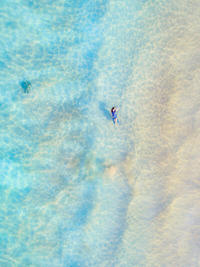 woman wearing blue kasia kulenty gown photographed by drone on maui with sea turtle