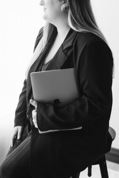 Newborn photographer holding her laptop offering education