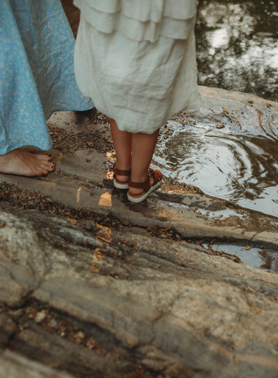 A little girl's feet touching the water in the creek in Christiansburg, Virginia