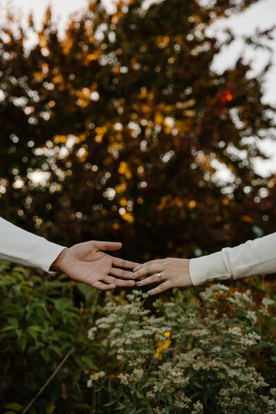 bride and groom holding hands around a corner