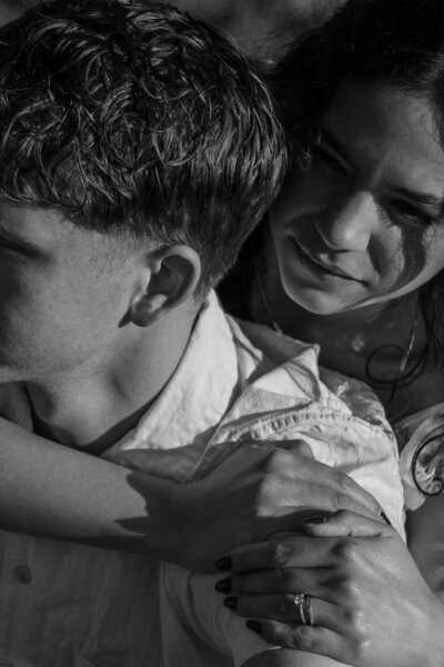 Elizabeth hugging David from behind, in black and white.