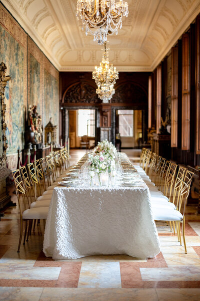 Long reception table with gold chairs at Larz Anderson House