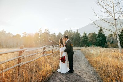 Bride and Groom Kissing on Rustic Path at Sunset