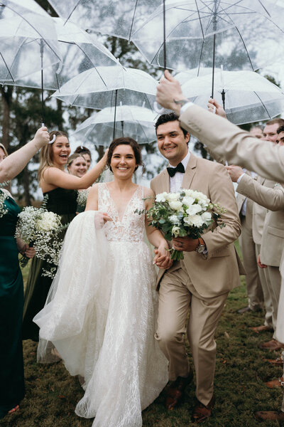 bridal party with clear umbrellas and rain on the wedding day.