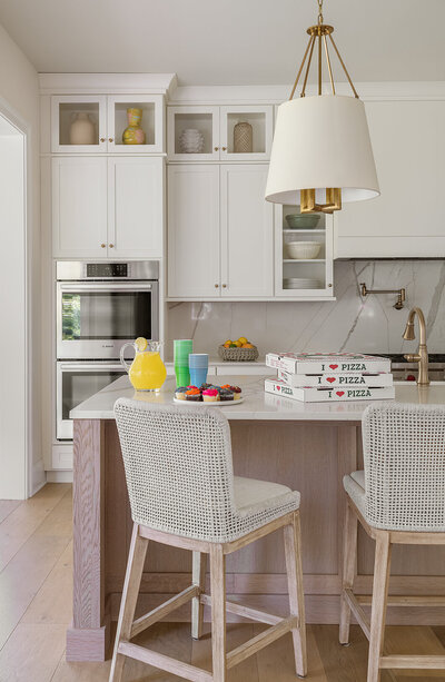 bright white kitchen with light wood accents and chairs