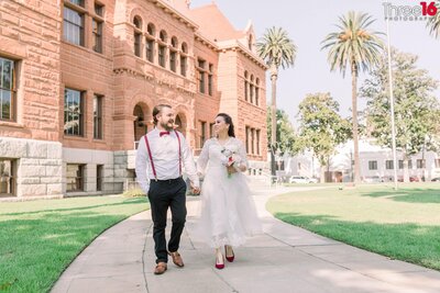 Bride and Groom stop to look at each other atop the stairs at the Old Orange County Courthouse in Santa Ana