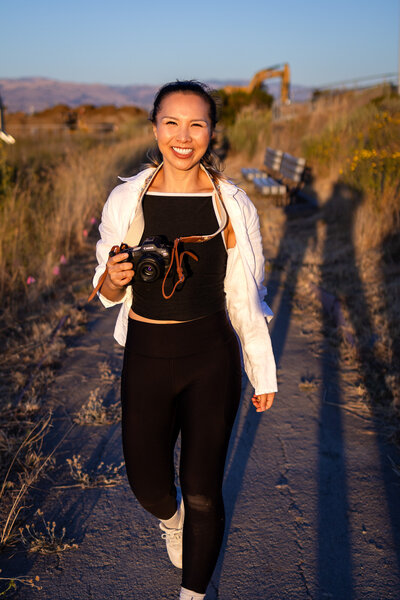 Bay Area Lifestyle Photographer - Ellobelle Photography Family Photographer walking joyfully on trail at sunset with camera