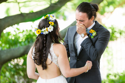 Crying groom with hands covering face during First Look at outdoor Dallas Wedding